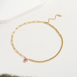 Vue détaillée du pendentif cœur en zircon rose sur chaîne asymétrique dorée 18K