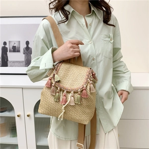 Straw drawstring backpack with colorful tassels on a lifestyle background