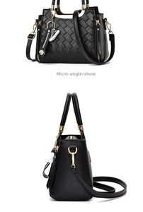 Detail of black quilted shoulder bag featuring gold hardware and a daisy charm pendant