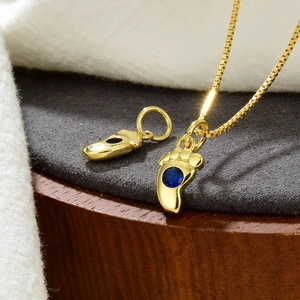 Nahaufnahme eines goldenen Fußanhängers mit blauem Zirkon für DIY-Schmuck