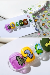 Macro detail of 3D embossed dinosaur nail stickers showing textures on colorful nails