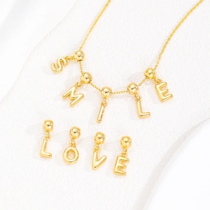 18k gold plated copper balloon letter necklace featuring SMILE and LOVE bubble charms
