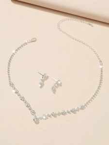 Detailed top view of V-shaped rhinestone necklace and matching earring set in silver