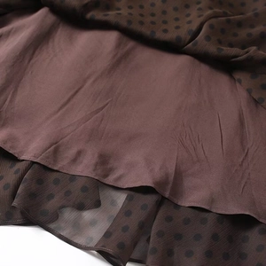 Detail aus braunem Tupfen-Chiffon mit glattem Satinfutter an einem unregelmäßigen Rock
