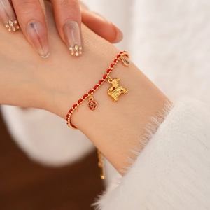On-model view of an 18K gold-plated red woven bracelet with a zodiac dog charm