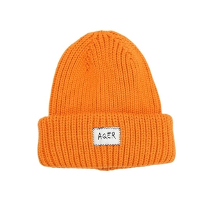 Oversized bright orange chunky knit beanie with a stylish logo patch for winter warmth