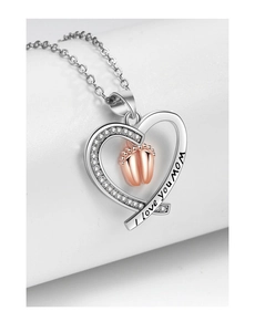 Macro shot of silver heart necklace with I love you Mom engraving and rose gold baby feet