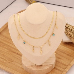 Double-layer gold necklace with turquoise beads and lightning bolt pendants on mannequin