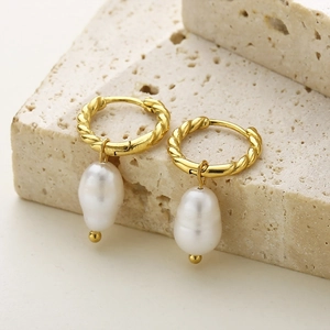 Elegant gold twisted hoop earrings with baroque pearls on a beige stone base