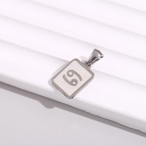 Macro view of rectangular silver pendant with numerical engraving on a white display