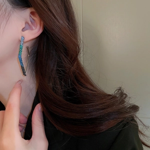 Close-up of geometric rhinestone drop earring with blue gradient crystals on a model