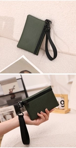 Détail d'un porte-monnaie en toile vert foncé avec zip et dragonne amovible pratique