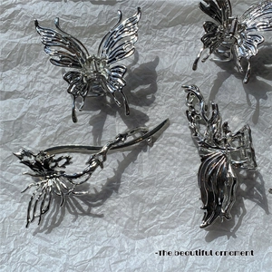 Silver liquid metal irregular butterfly hair claw clips set on textured white background