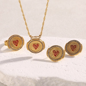 Macro shot of 18K gold plated jewelry set with red enamel hearts and small crystals