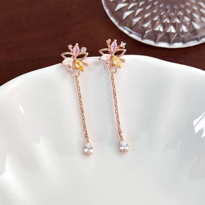 Macro shot of rose gold tassel earrings with zircon flower design and teardrop crystal