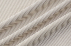 Gros plan sur le tissu en maille côtelée beige montrant la texture et la qualité du textile