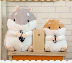 Detail view of plush hamster keychains in grey and brown holding seeds on wooden surface