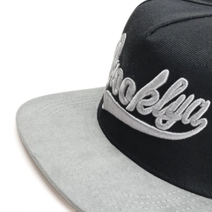 Détail de la broderie 3D Brooklyn et de la texture bicolore sur une casquette à bord plat