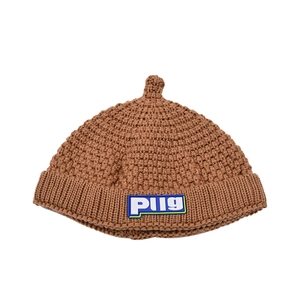 Detailed close-up of brown knit baby beanie showing chunky texture and PUG patch