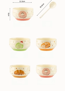 Close-up of ceramic bowl with cute dessert patterns and matching long handle spoon