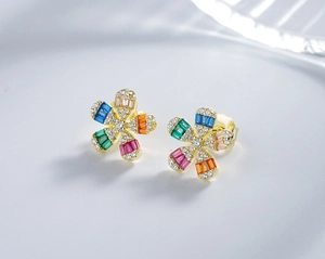 Macro shot of silver daisy earrings with colorful pavé cubic zirconia and gold plating