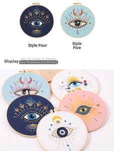 Detail showing embroidered evil eye patterns with sequins on colorful fabric in wooden hoops