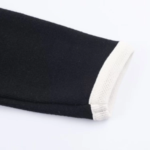 Makro-Detail der hochwertigen schwarz-weißen Kontrast-Strickbündchen am Mini-Kleid
