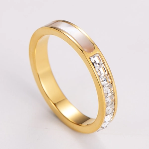 Macro detail of gold stainless steel ring featuring white mother of pearl and square zircons