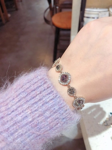 Detail of rose gold bracelet featuring round charms with crystals and pave-set diamonds