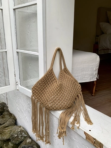 Dettaglio della borsa boho in corda con frange, elegante borsa da spiaggia color kaki.
