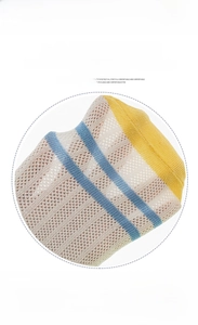 Detailed macro view of breathable mesh knit texture on beige baby socks with blue stripes