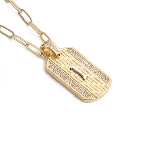 Gros plan détaillé du collier croix doré avec incrustation de zircon et chaîne trombone