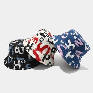 Detailed view of colorful graffiti print bucket hats in black, white and blue canvas