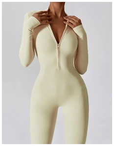 Close-up of the front metal zipper and stand collar on the cream yoga bodysuit