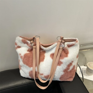 Chic oversized plush tote bag featuring pink cow print pattern and premium leather straps