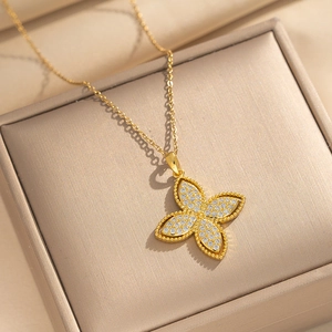 Collier trèfle élégant en acier titane doré avec oxydes de zirconium sur un écrin à bijoux