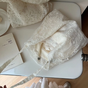 Detailed close-up of French lace embroidery cotton bag with simple wish brand tag