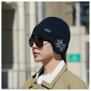 Detail of navy blue winter knit hat with snowflake pattern and ear flaps for men