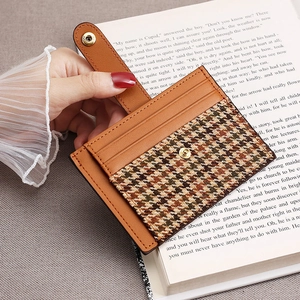 Slim brown leather card holder with houndstooth pattern and snap button closure