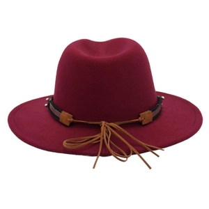 Close-up of wine red fedora hat with black woven band and leather tassel detail