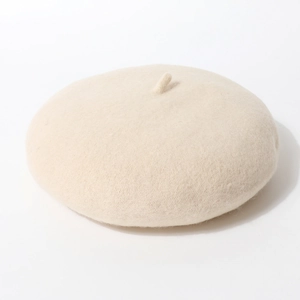 Detailopname van de gebroken witte wollen baret met zachte textuur en gebreid detail