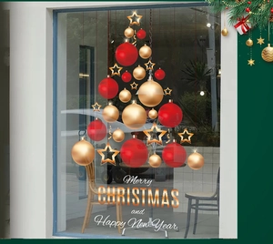 Détail de stickers de Noël rouges et dorés avec boules et étoiles sur une vitrine