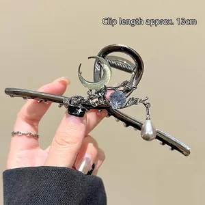 Detail view of a 13cm metal hair claw clip with floral moon and pearl pendant decor