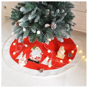 Close-up of red Christmas tree skirt featuring Santa Claus applique and white plush border