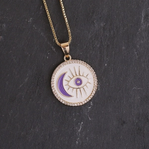 Macro shot of 18K gold plated necklace with moon, evil eye pendant and zircon stones