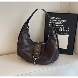 Close-up of dark brown hobo bag with silver star rivets and premium leather texture