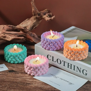 Set of four colorful candles with woven rope texture on a rustic wooden table setup