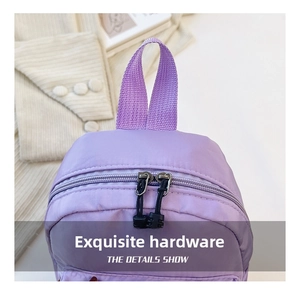 Detail shot of purple nylon backpack with durable double zippers and woven top handle