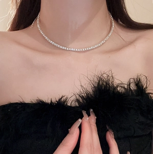 Close-up of silver tennis necklace with zircon studs worn on a model's collarbone