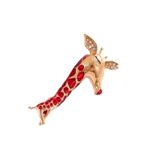 Cute gold giraffe brooch with red enamel spots and sparkling diamond accents on white background